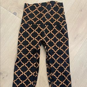 K-Deer Capri length black and gold leggings.